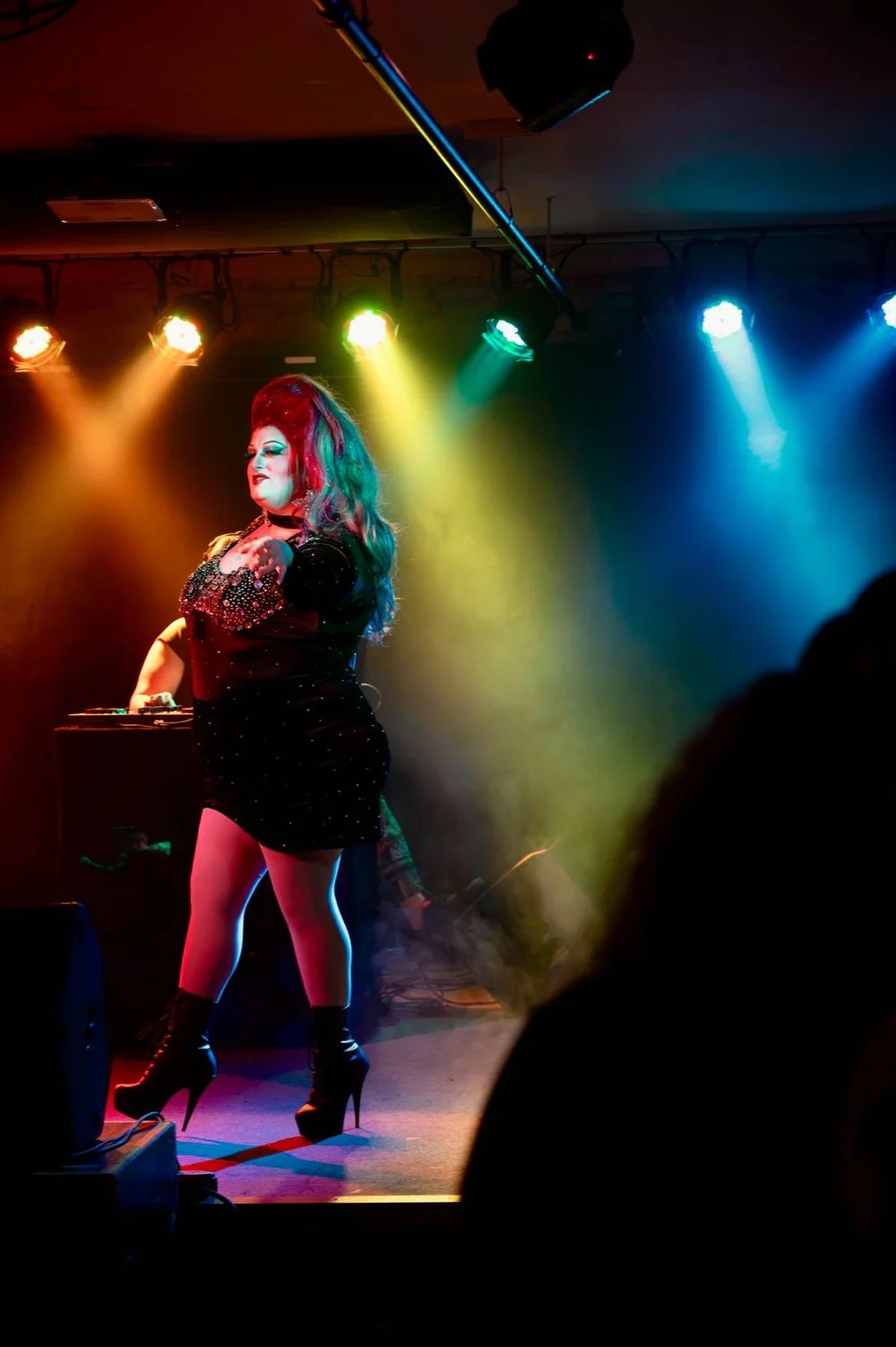 A Pride in Pontiac performer on stage under yellow and blue spotlights